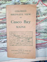 Load image into Gallery viewer, Photo of the original booklet cover that is brown paper with green printing and says Colored Bird's-eye view of Casco Bay Maine Walker Lith & Pub Co