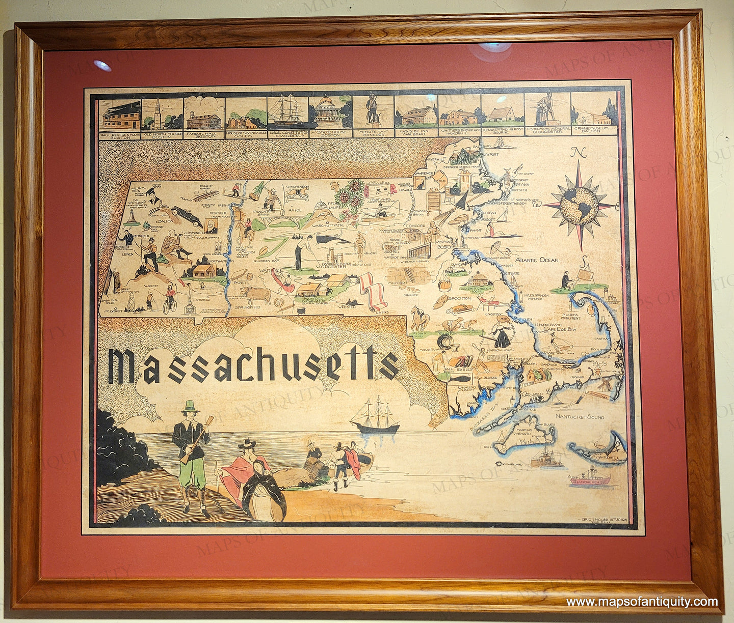 Framed vintage map of Massachusetts with illustrations framed with a red mat and wood frame. 