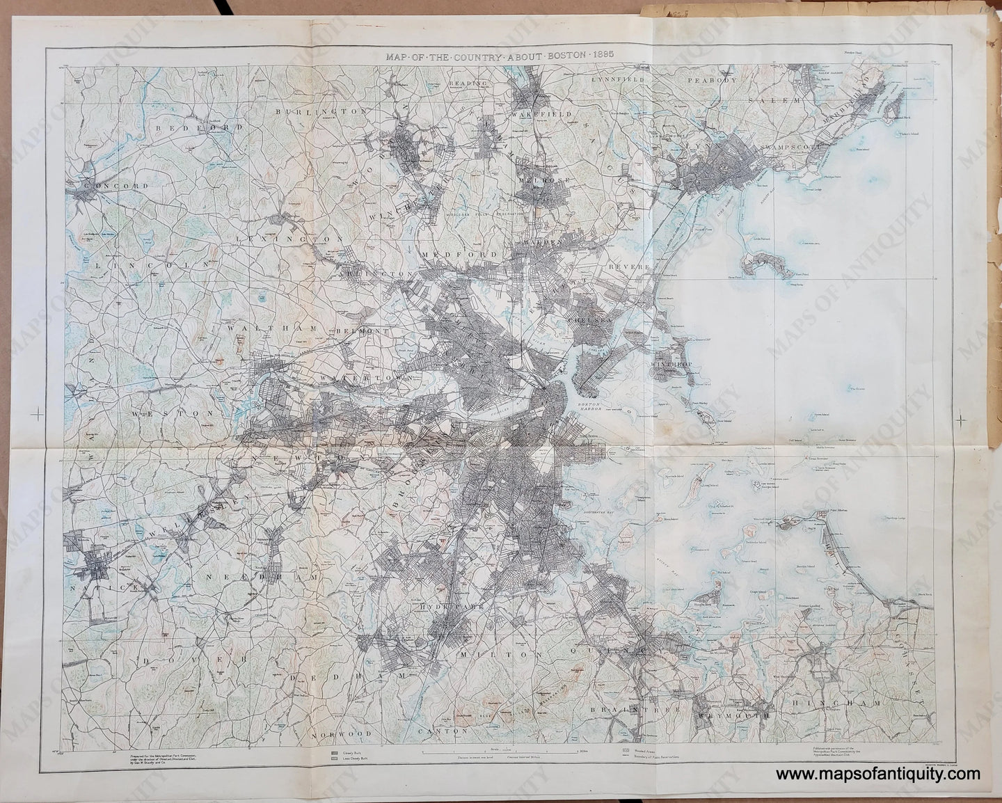 Impressive map with the city of Boston at center, with darkly shaded areas indicating densely populated areas, green shows forests and brown lines indicate topography. The Public Reservations are noted.